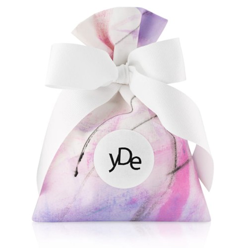 Opakowanie do perfum. Ręcznie malowany w nieregularne wzory elegancki biały bawełniany woreczek z żakardowym logo yDe, zawiązany białą kokardą.