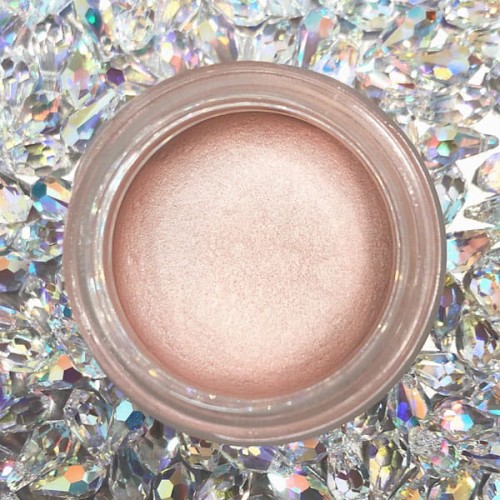 Naturalny kremowy rozświetlacz glow & beauty w delikatnym, różowo-beżowym odcieniu, umieszczony w okrągłym słoiczku.